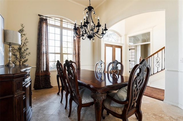 dining space with an inviting chandelier, crown molding, and french doors