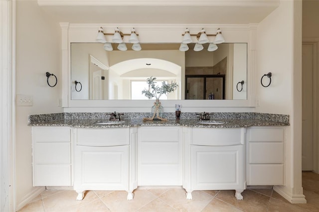 bathroom featuring tile patterned flooring, vanity, and a shower with shower door