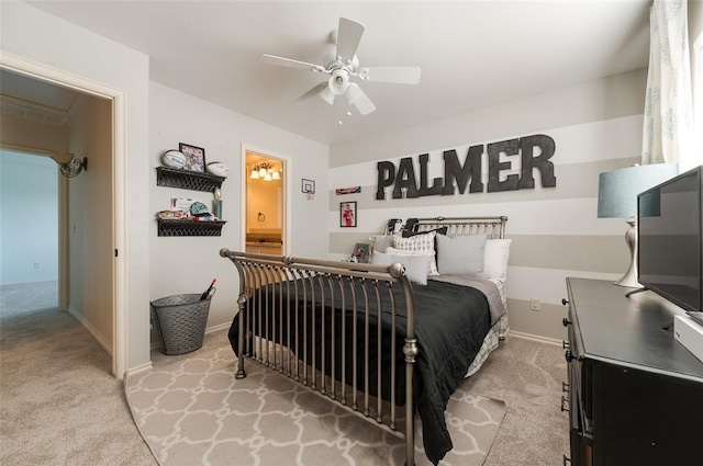 carpeted bedroom with ceiling fan and ensuite bathroom