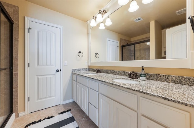 bathroom with an enclosed shower, vanity, and tile patterned floors