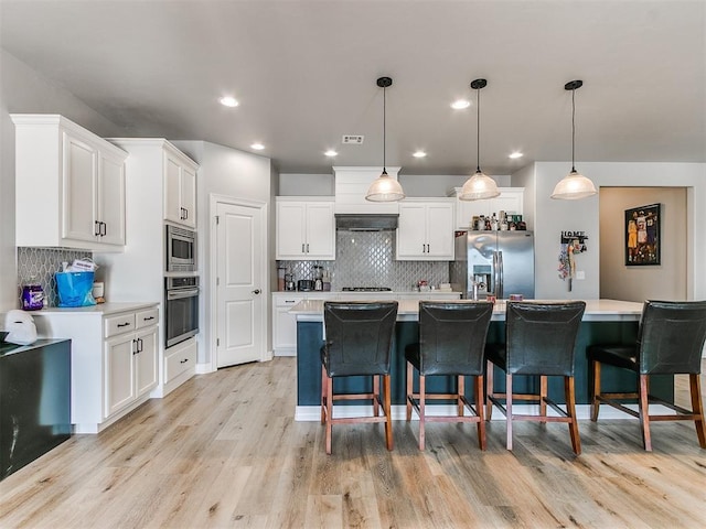 kitchen with white cabinetry, pendant lighting, an island with sink, and appliances with stainless steel finishes