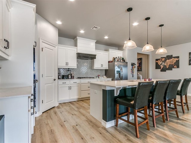 kitchen featuring tasteful backsplash, stainless steel appliances, hanging light fixtures, and white cabinets