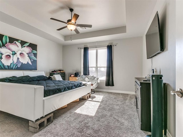 bedroom with light carpet, a raised ceiling, and ceiling fan