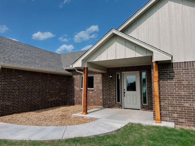 210 S Noble Ave, Hinton, OK 73047 - entrance to property with brick siding, a shingled roof, and a patio