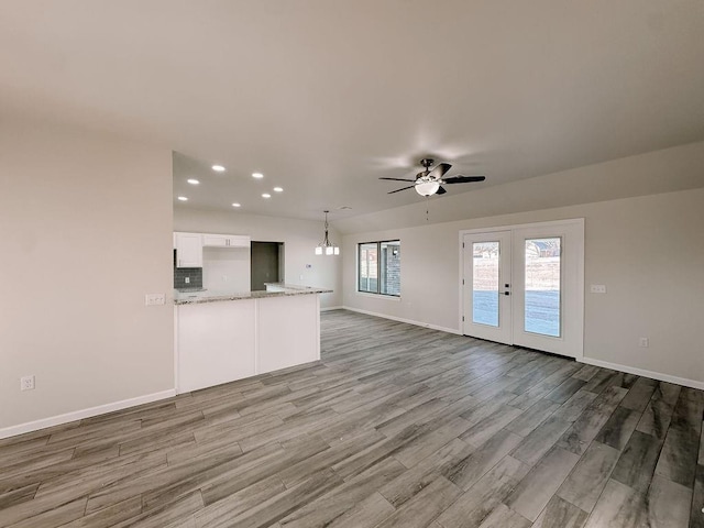 210 S Noble Ave, Hinton, OK 73047 - unfurnished living room featuring wood finished floors, a ceiling fan, baseboards, recessed lighting, and a chandelier