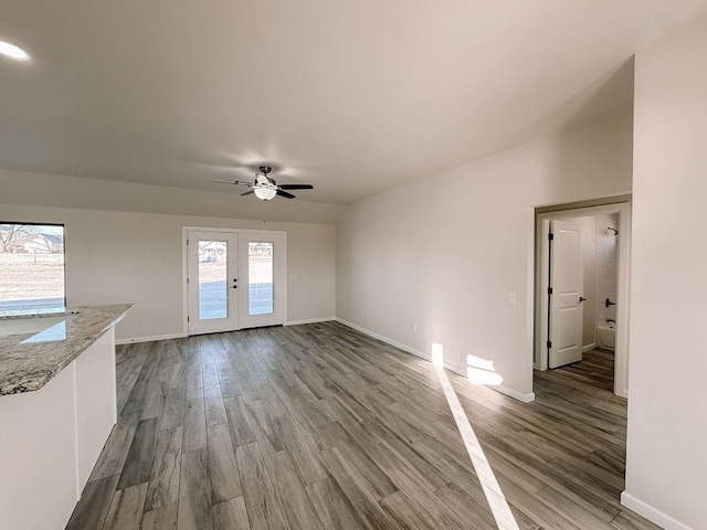 210 S Noble Ave, Hinton, OK 73047 - unfurnished living room with baseboards, french doors, and wood finished floors