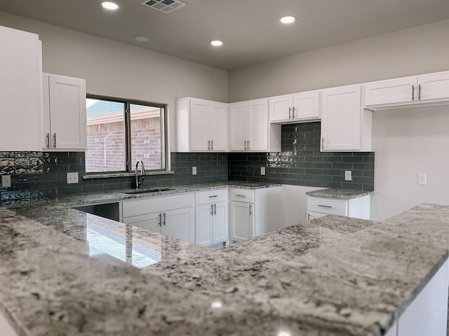 210 S Noble Ave, Hinton, OK 73047 - kitchen featuring light stone counters, a sink, white cabinets, tasteful backsplash, and recessed lighting