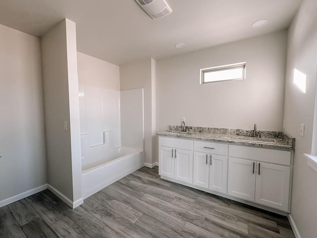 210 S Noble Ave, Hinton, OK 73047 - bathroom with double vanity, baseboards, wood finished floors, and washtub / shower combination
