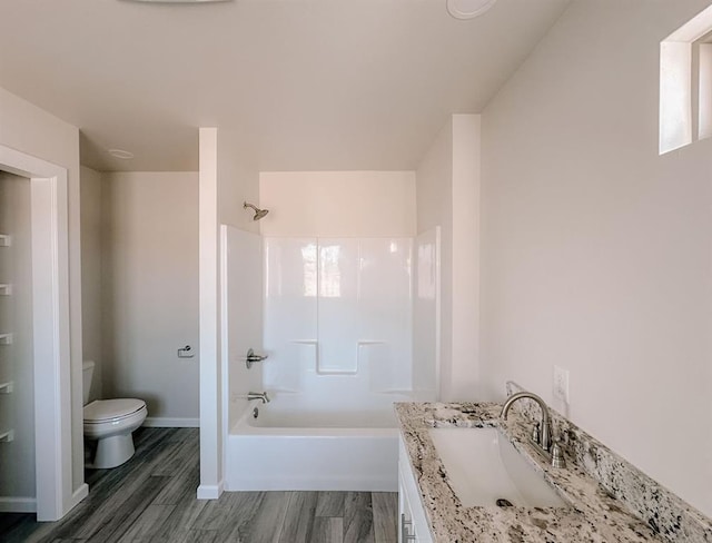 210 S Noble Ave, Hinton, OK 73047 - bathroom featuring toilet, vanity, shower / bathtub combination, wood finished floors, and baseboards