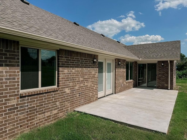 210 S Noble Ave, Hinton, OK 73047 - back of property featuring brick siding, a shingled roof, and a patio