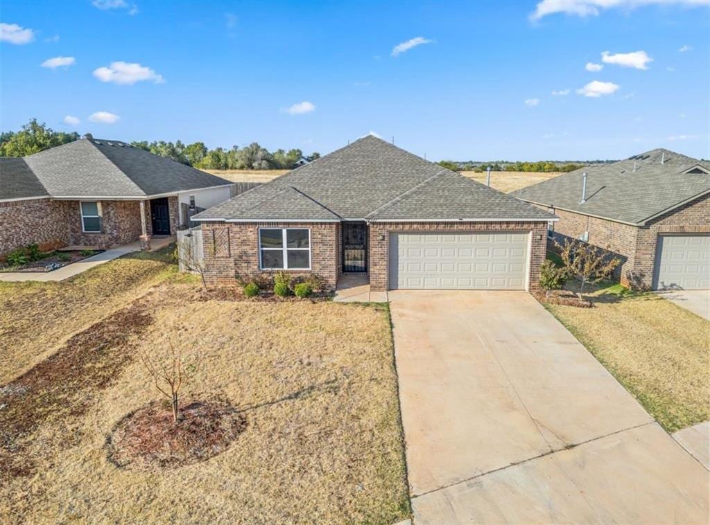 single story home with a garage and a front lawn