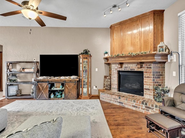 living room featuring a fireplace, wood-type flooring, and ceiling fan