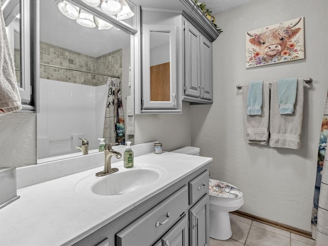 bathroom with tile patterned flooring, vanity, walk in shower, and toilet