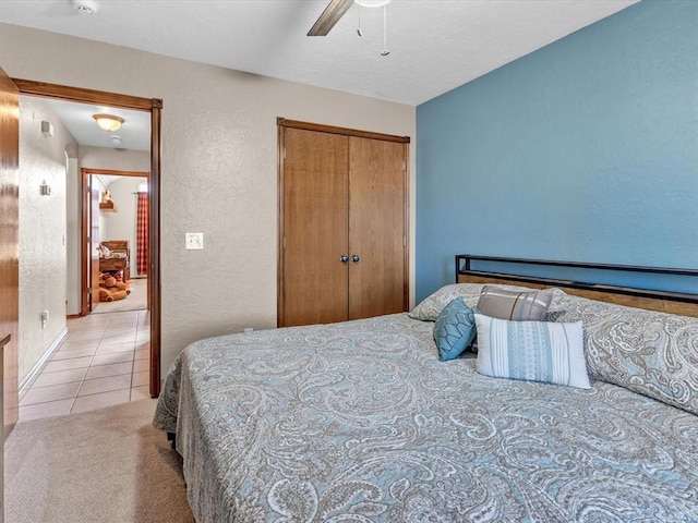 bedroom featuring light carpet, a closet, and ceiling fan