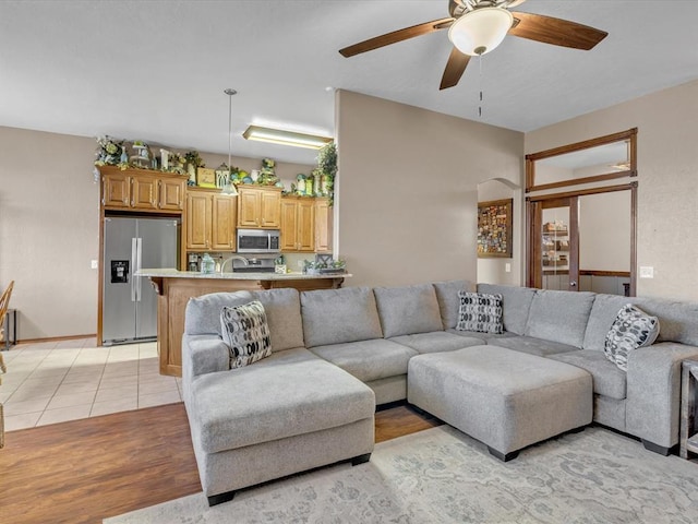 living area featuring ceiling fan and light tile patterned floors