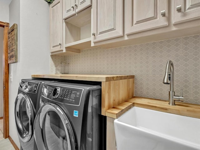 laundry area featuring cabinet space, a sink, and washing machine and clothes dryer