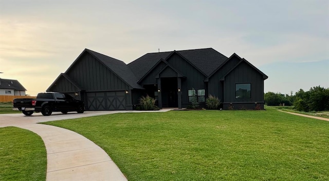 modern inspired farmhouse featuring a garage and a lawn