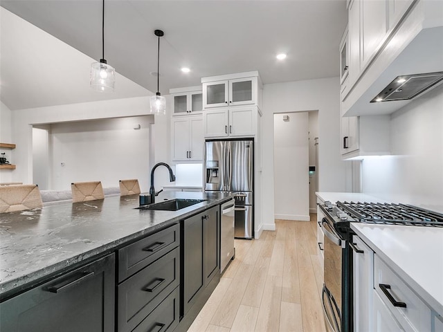 kitchen featuring sink, stainless steel appliances, white cabinets, decorative light fixtures, and light wood-type flooring