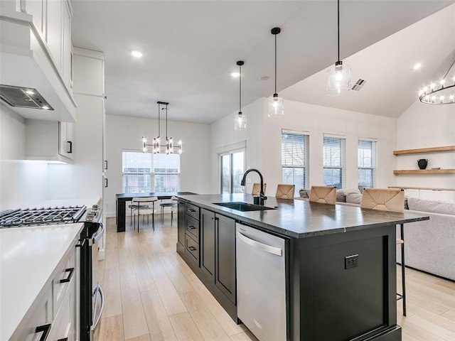 kitchen featuring white cabinetry, sink, stainless steel appliances, and a center island with sink