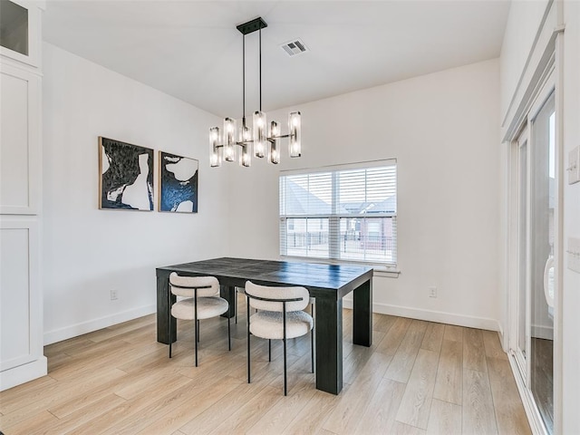 dining room with a notable chandelier and light wood-type flooring