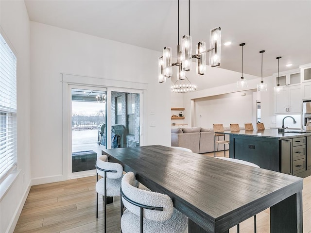 dining area with sink, a wealth of natural light, and light hardwood / wood-style flooring