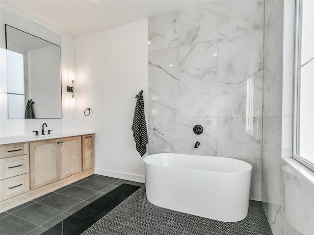 bathroom featuring vanity, a washtub, and tile patterned floors