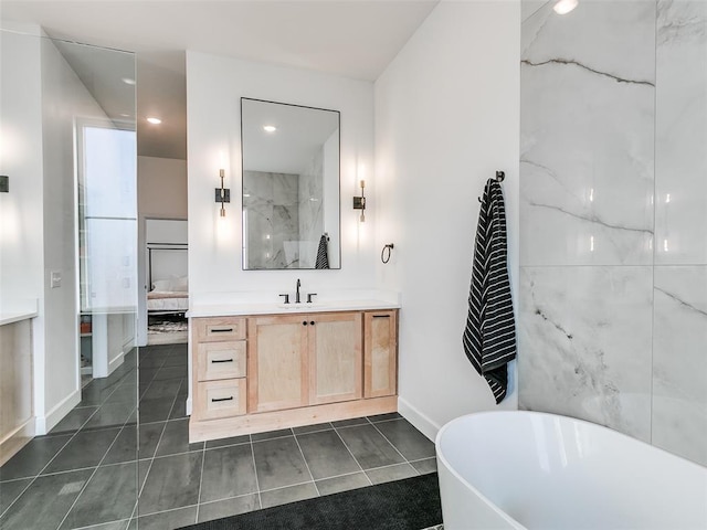 bathroom featuring tile patterned flooring, a bath, and vanity