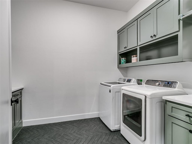 washroom featuring cabinets, dark parquet flooring, and washer and clothes dryer