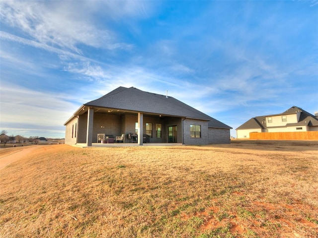 rear view of property with a patio area and a lawn