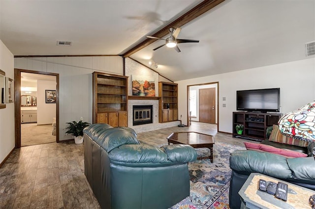 living room with lofted ceiling with beams, ceiling fan, hardwood / wood-style flooring, and a fireplace