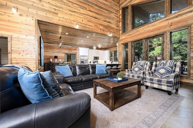 living room with a towering ceiling and wooden walls