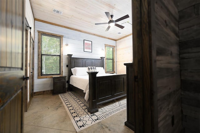 bedroom featuring concrete flooring, visible vents, and wooden walls