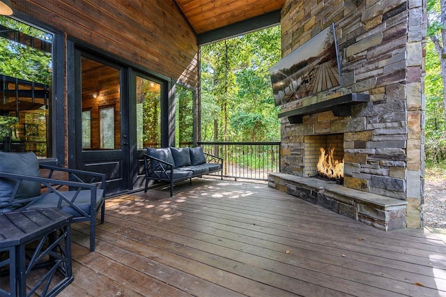 deck featuring an outdoor stone fireplace