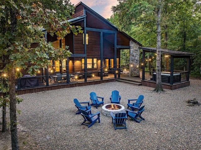 65 Rocky Rose Cir, Broken Bow, OK 74728 - back of house at dusk with a fire pit and a deck