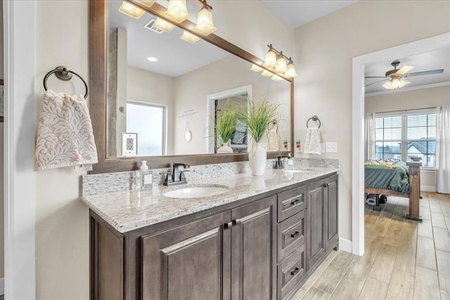 bathroom with hardwood / wood-style flooring, ceiling fan, and vanity