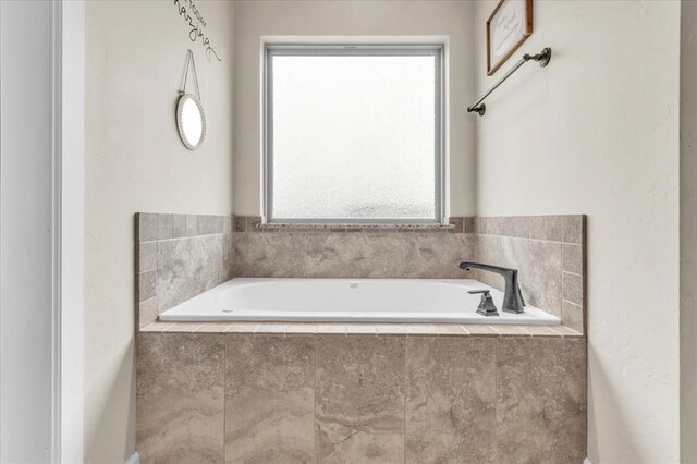 bathroom with a relaxing tiled tub