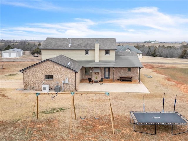 back of property featuring a patio, cooling unit, and a trampoline