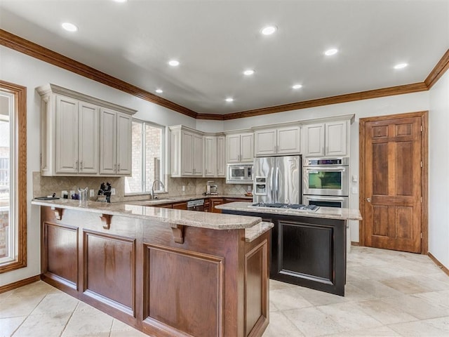 kitchen with stainless steel appliances, a center island, sink, and light stone countertops