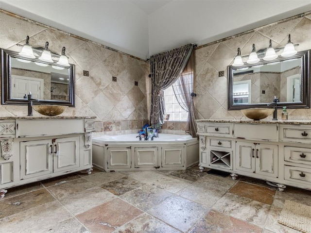 bathroom featuring vanity, a washtub, and tile walls