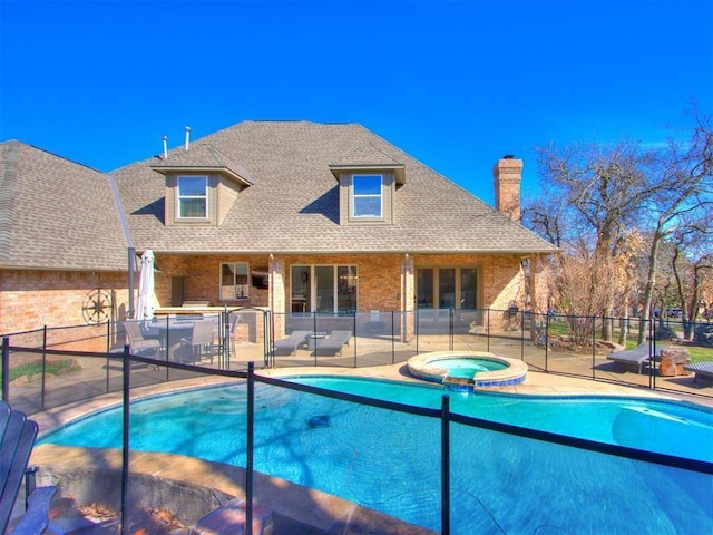 view of swimming pool featuring an in ground hot tub and a patio area