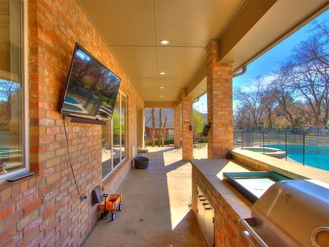 view of patio with area for grilling and a swimming pool with hot tub