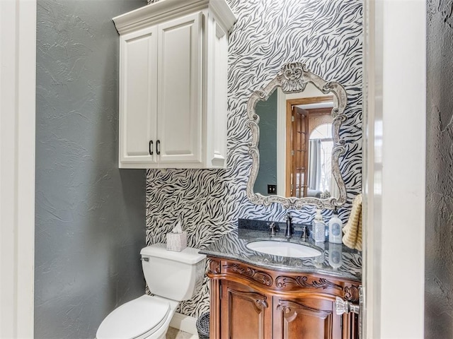 bathroom with vanity, toilet, and decorative backsplash