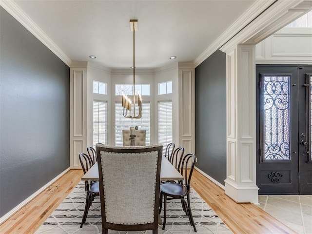 dining room featuring a notable chandelier, ornamental molding, and light wood-type flooring