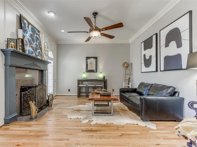 living room with crown molding, ceiling fan, and light hardwood / wood-style flooring