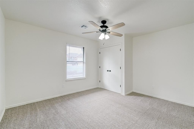 spare room with light colored carpet and ceiling fan