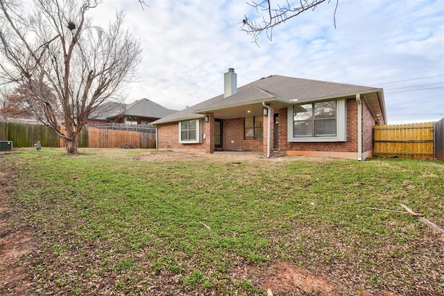 rear view of property with central AC and a lawn