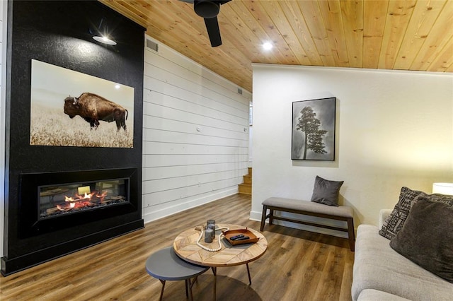 living room featuring hardwood / wood-style flooring, wooden ceiling, and wooden walls