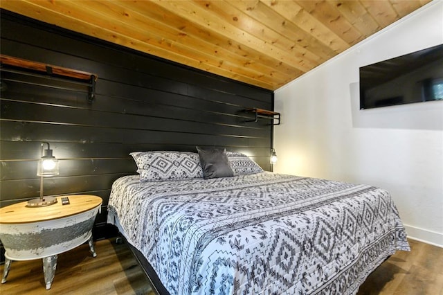 bedroom with dark wood-type flooring, wood ceiling, and wooden walls