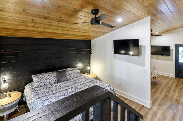 bedroom with hardwood / wood-style floors, wood ceiling, wooden walls, and ceiling fan