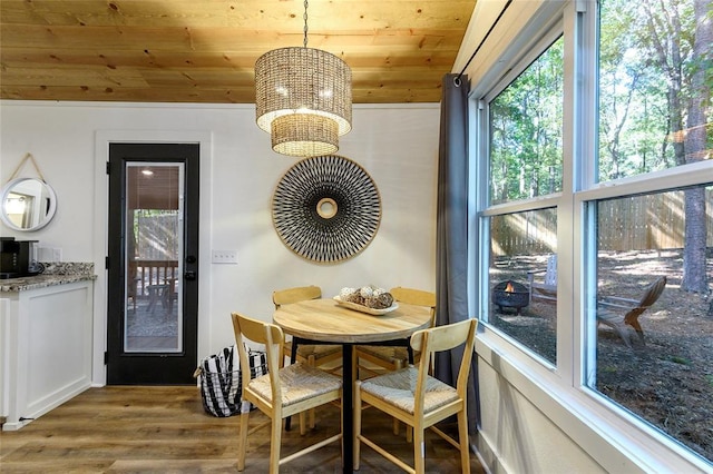 dining room with wood-type flooring, plenty of natural light, and wooden ceiling